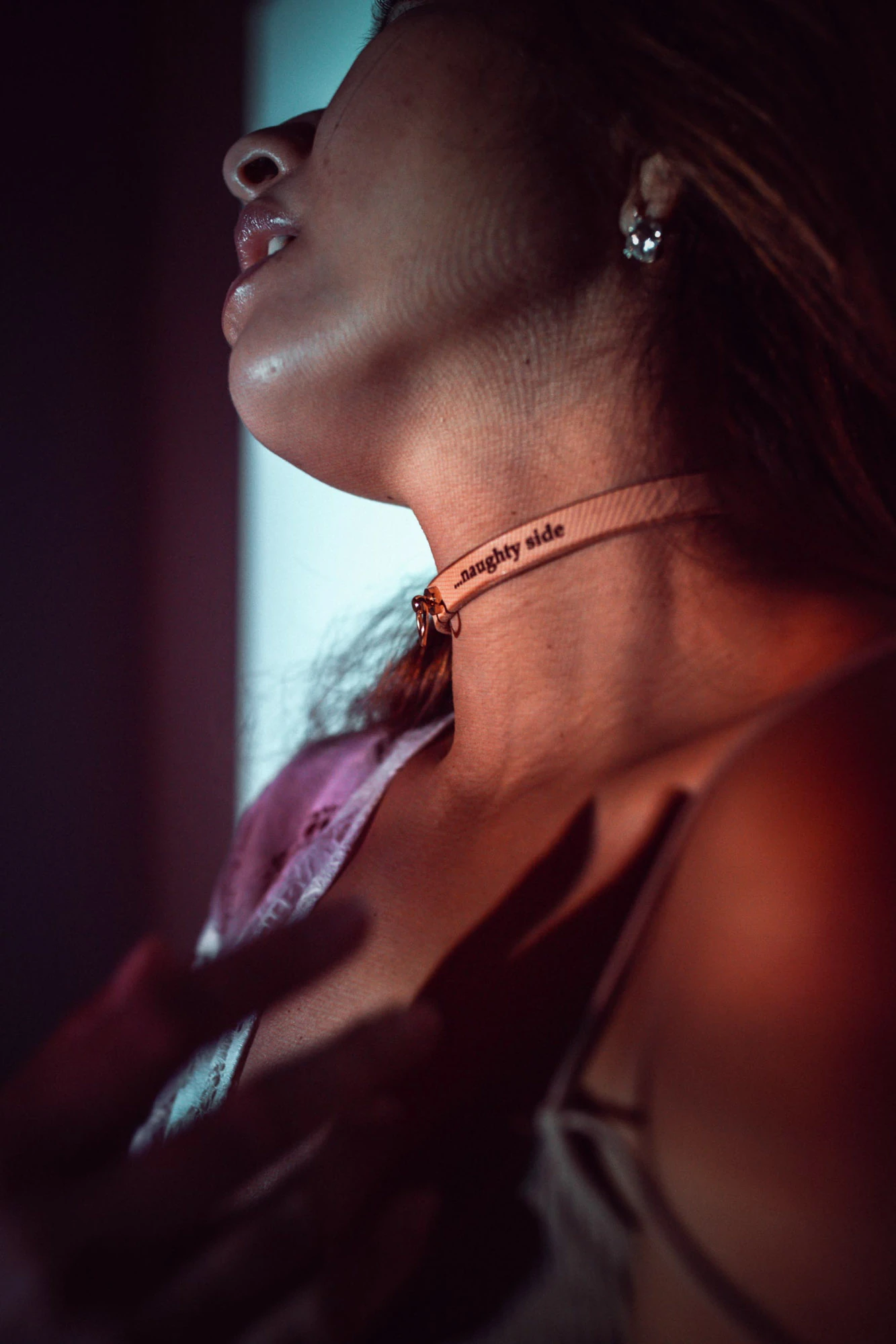 Cinematic profile portrait with delicate choker necklace in ambient moody light