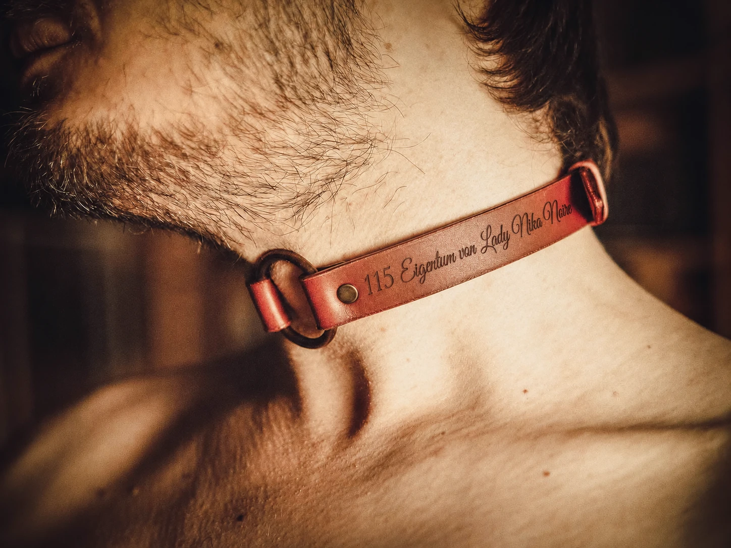 Close-up side profile of custom engraved leather collar on neck