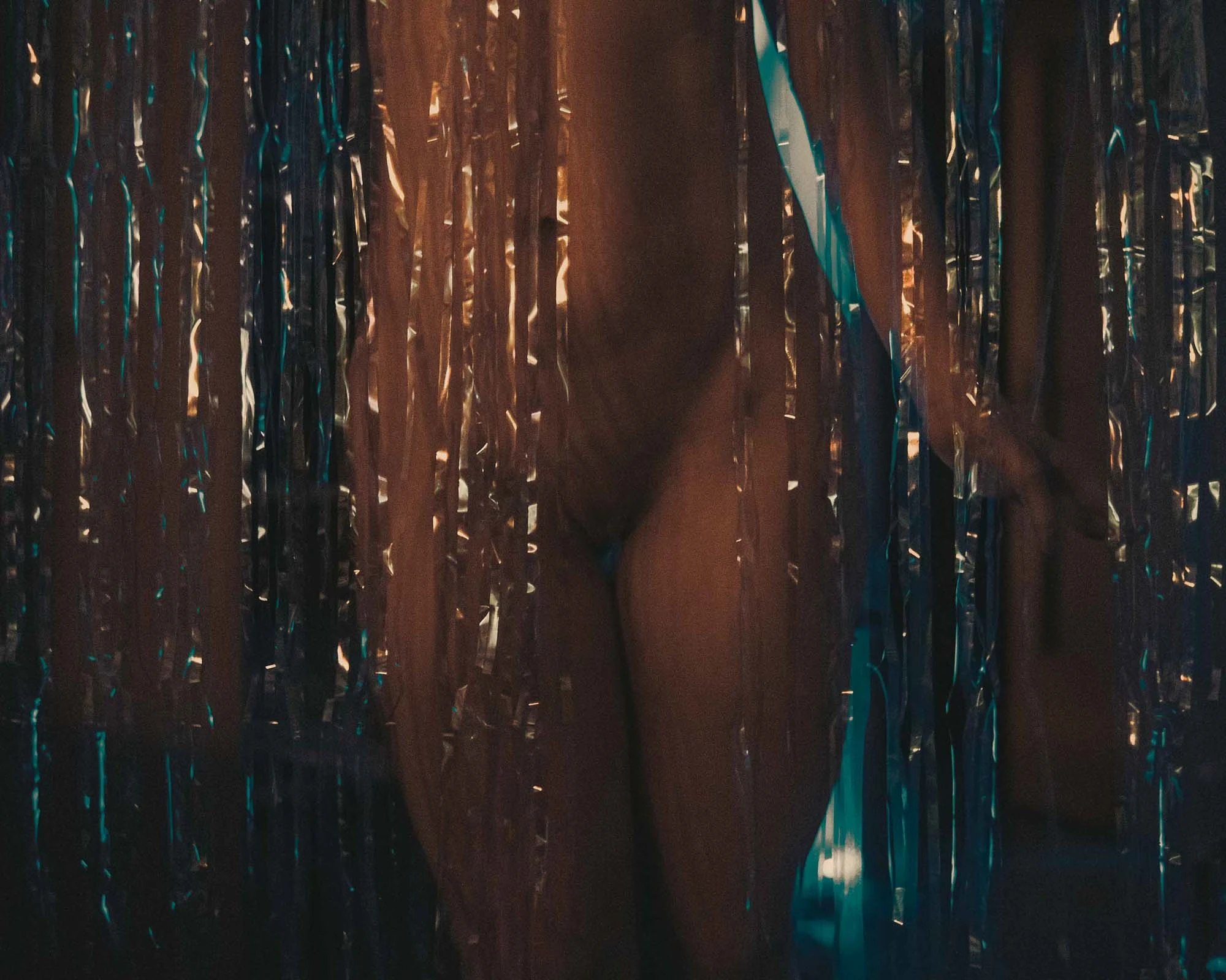 Creative silhouette shoot behind a reflective metallic fringe curtain