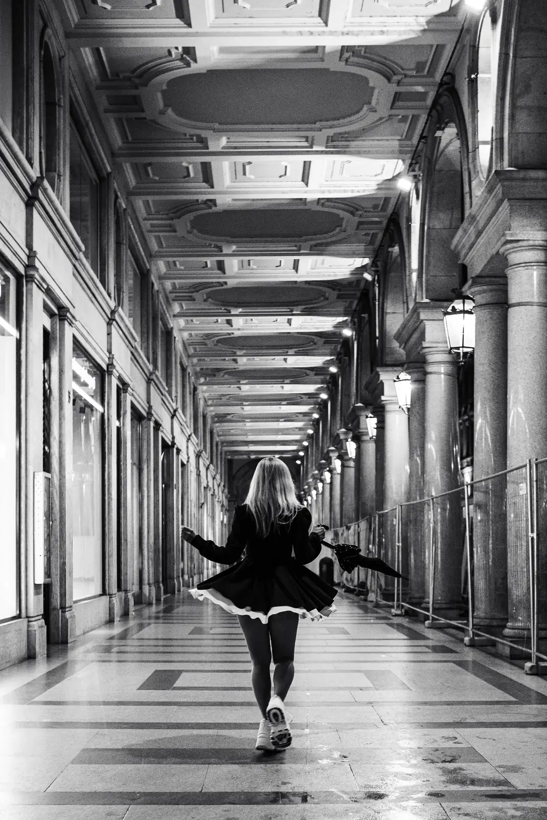 A traveler walking beneath Turin's historic porticoes